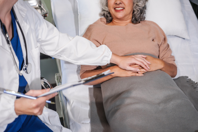 doctor holding patient's hand in hospital bed smiling patient receiving care and support health five essential elements